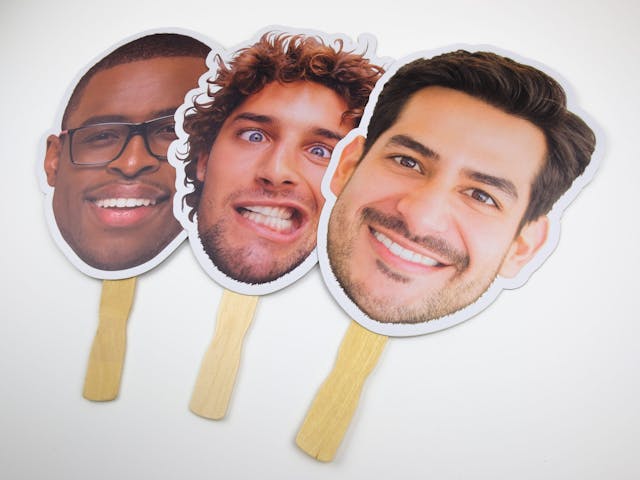 Three example men's faces attached to stakes